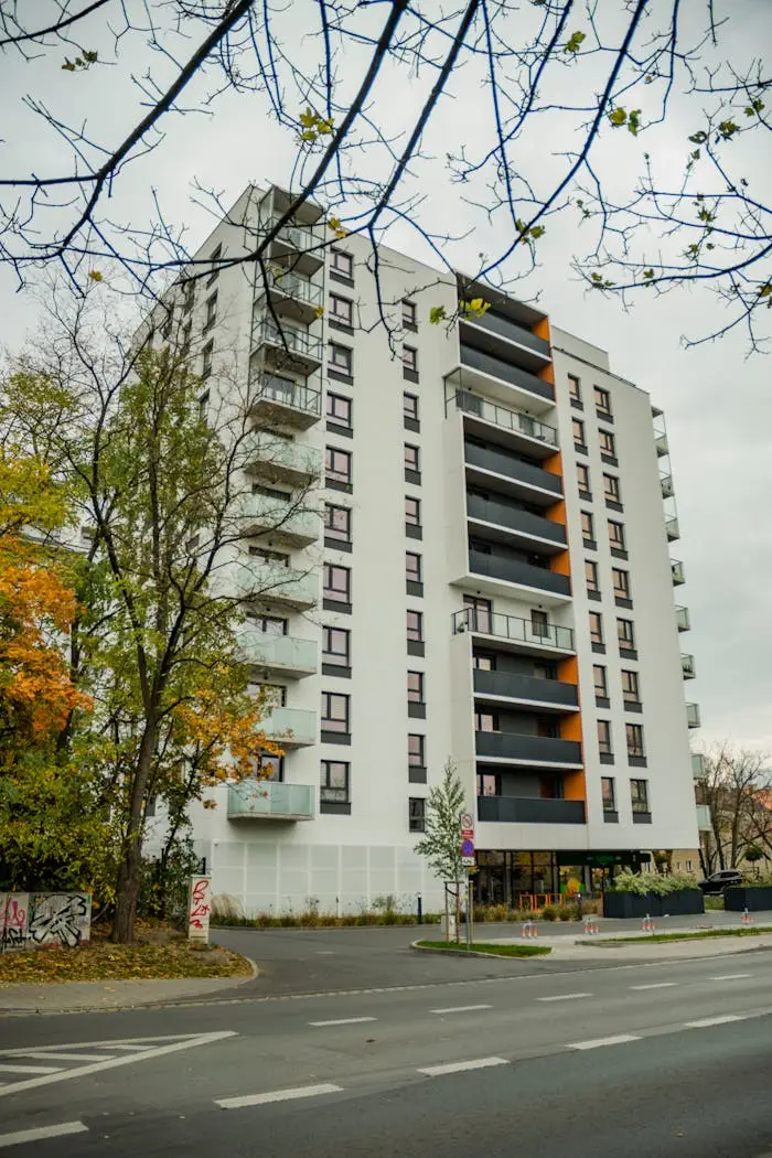 Services Contemporary apartment building with fall foliage in cityscape.