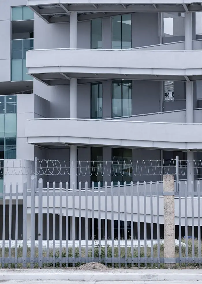 About Contemporary apartment complex with a minimalist design and fenced enclosure.